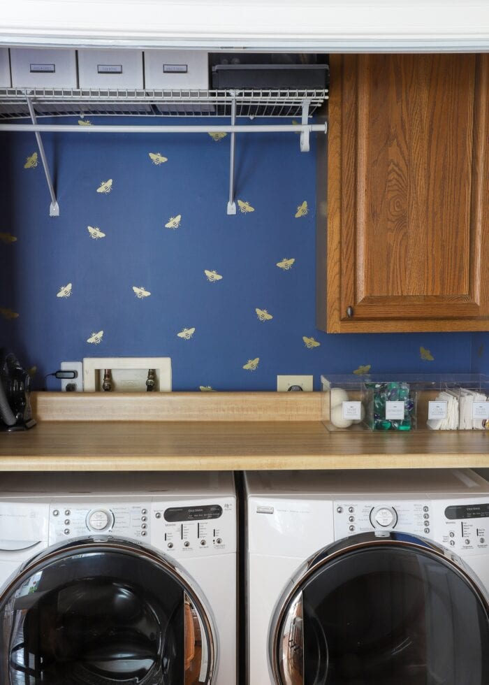Navy blue laundry room with gold bee vinyl decals made with a Cricut.