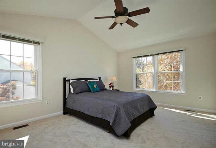 Beige master bedroom with a single bed and nightstand.