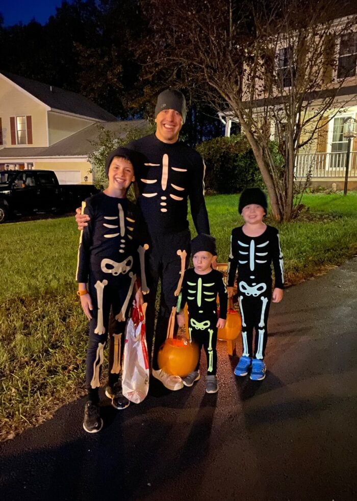 Three boys and Dad with glow-in-the-dark skeleton bones on black outfits.