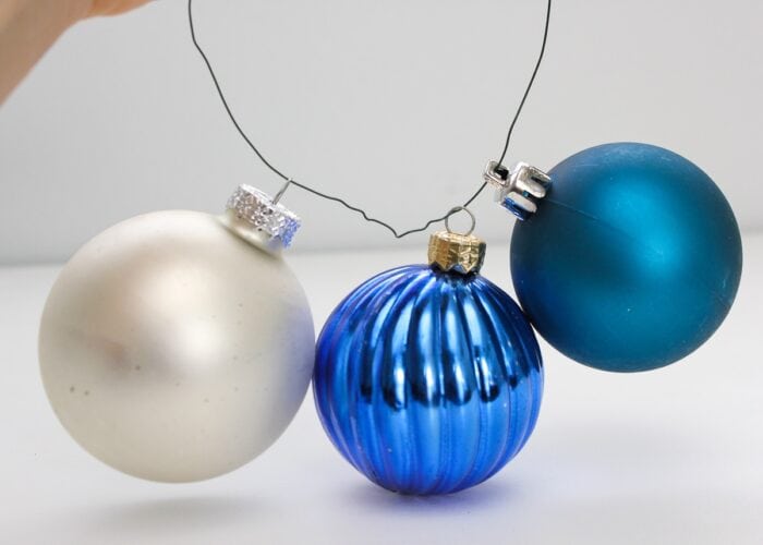 Blue, turquoise and white ornaments strung onto floral wire
