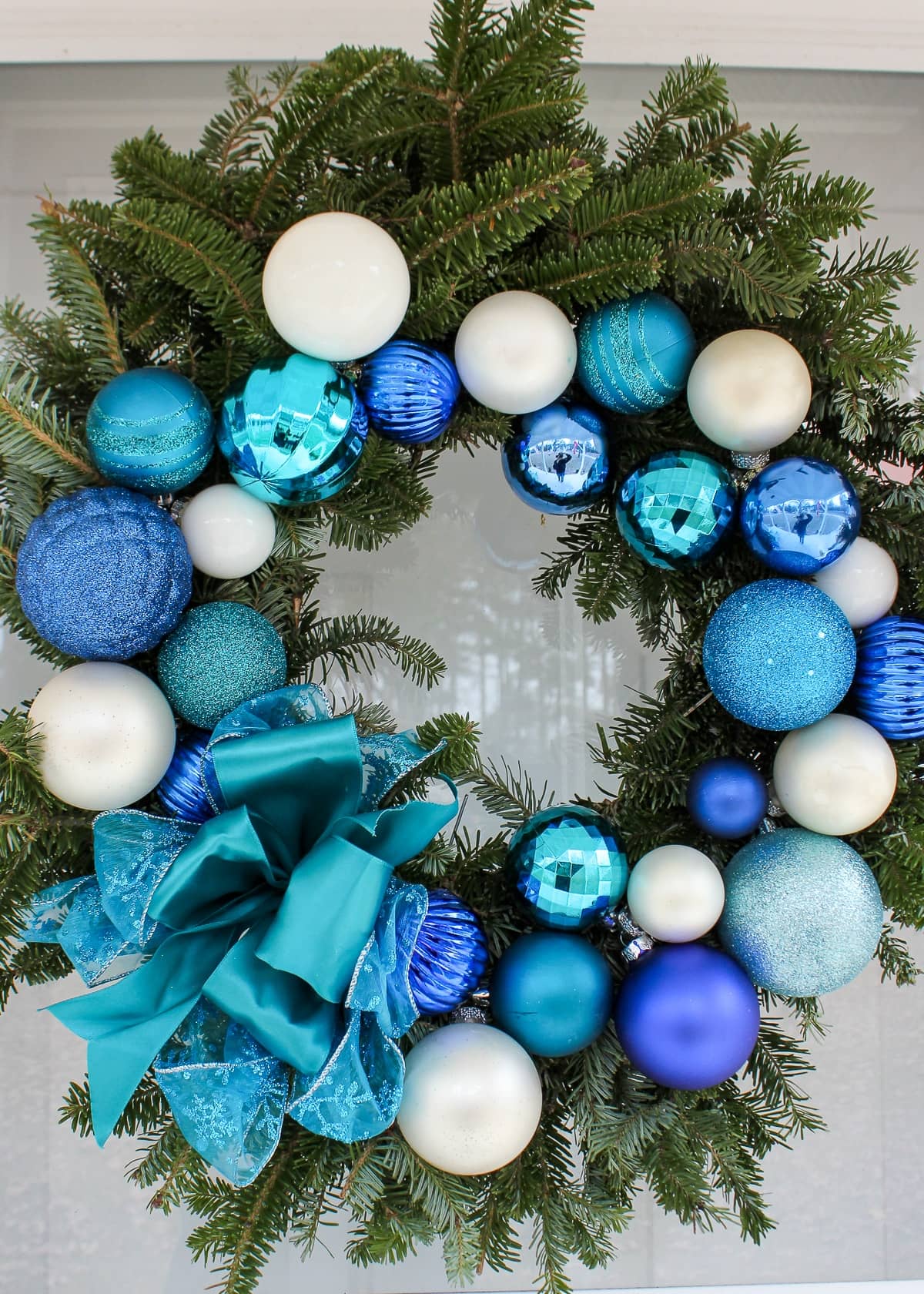 Turquoise, royal blue, and white ornaments on a pine wreath
