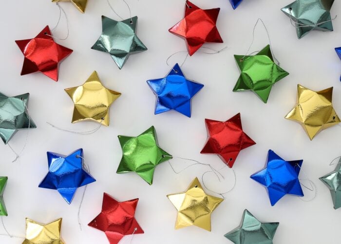 Paper star ornaments in red, blue, gold, and green.