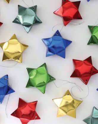 Paper star ornaments in red, blue, gold, and green.