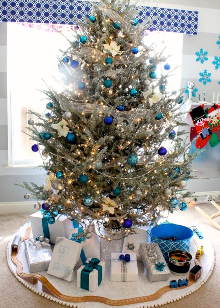 White flocked tree with blue, silver and turquoise Christmas ornaments.