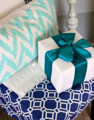 White present with turquoise bow on a chair.