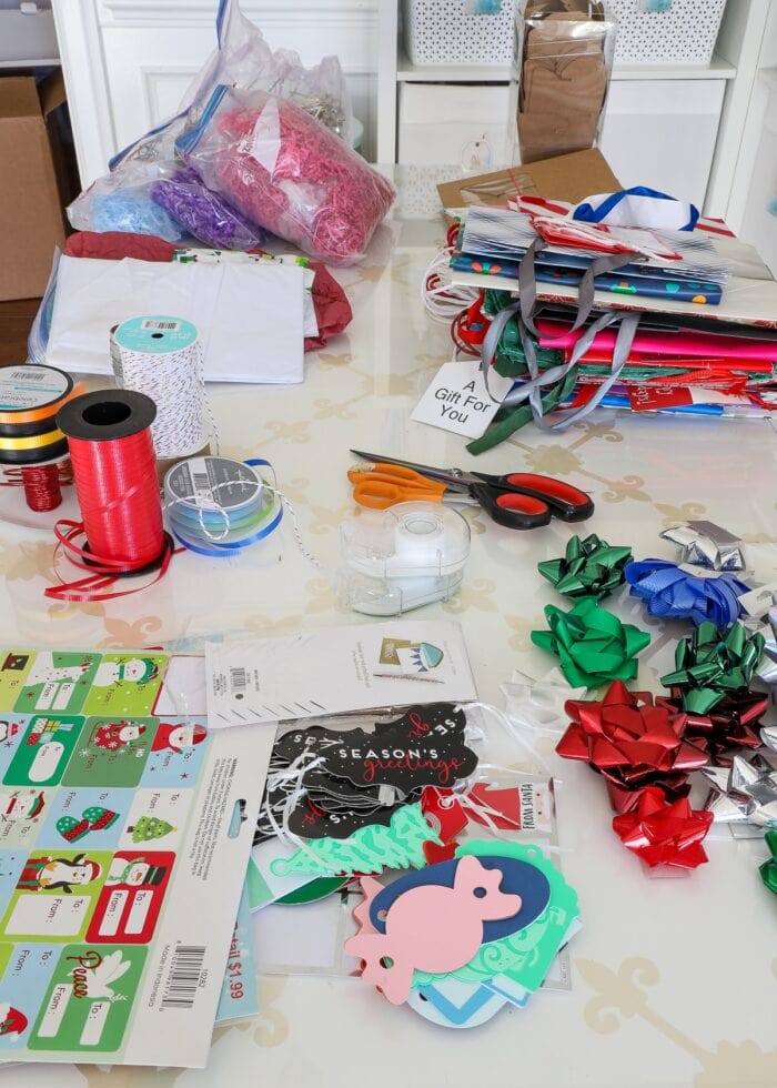 A mess of gift wrap supplies on a white table