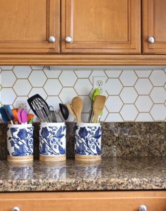 Blue and white flowered utensil jars on a granite countertop