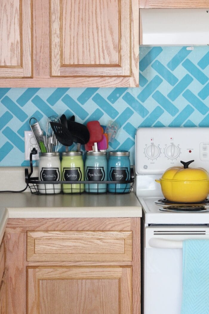 Turquoise kitchen backsplash with painted utensil jars