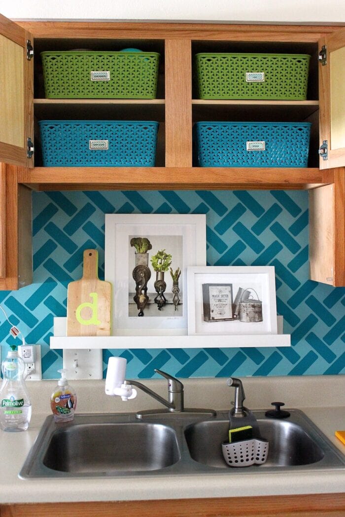 Tiny upper cabinets above a sink with blue and green baskets