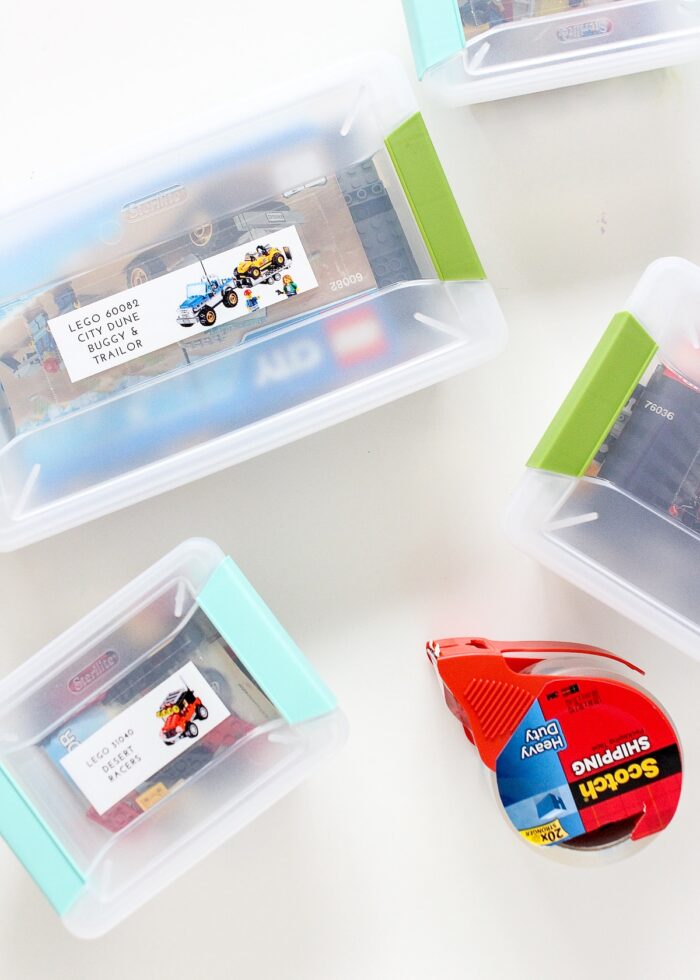 LEGO sets organized into plastic boxes with picture labels