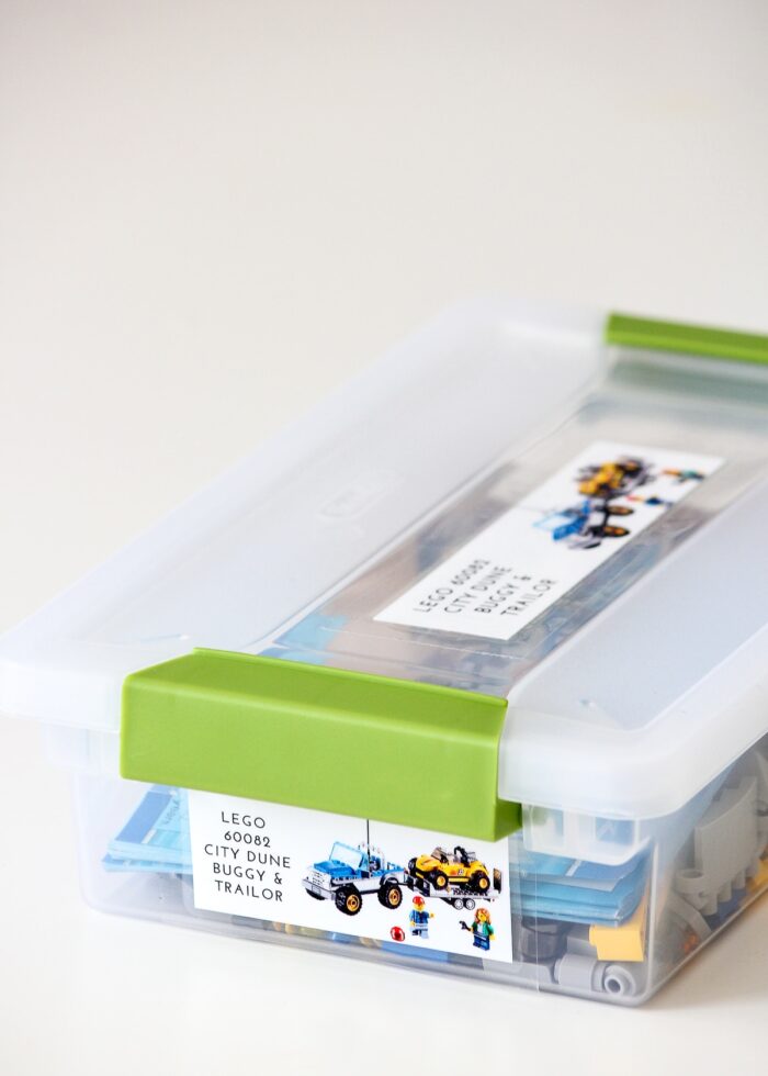 LEGO sets organized into plastic boxes with picture labels