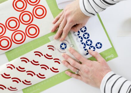 Cricut mat shown with red, white, and blue vinyl designs being layered together