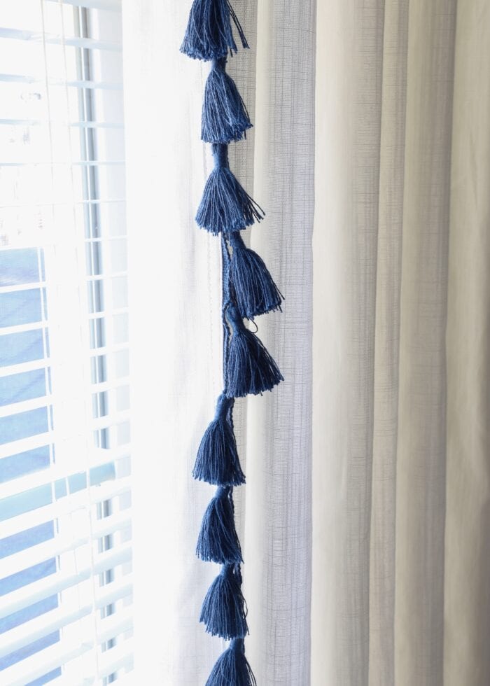 Navy tassels on the edge of a white curtain