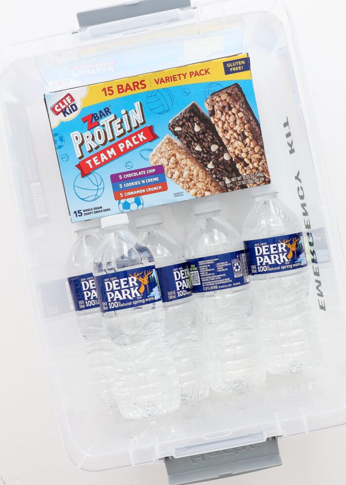 Plastic box shown with water bottles and granola bars