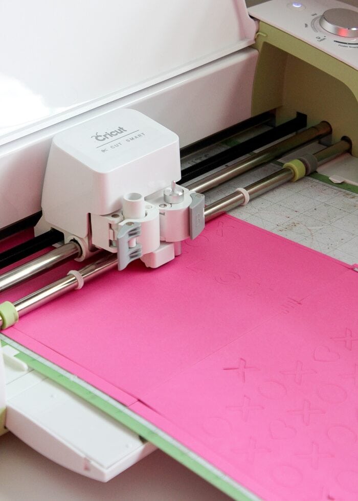 Pink paper loaded into a Cricut machine