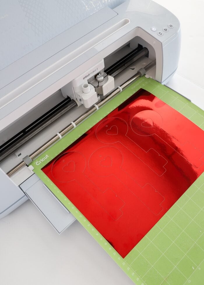 Red foil cardstock being loaded into a Cricut Maker 3