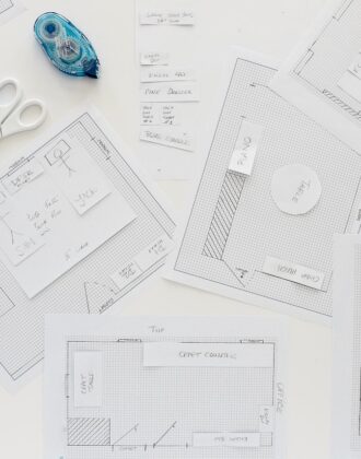 Overhead shot of a room layout drafted onto graph paper with furniture mockups