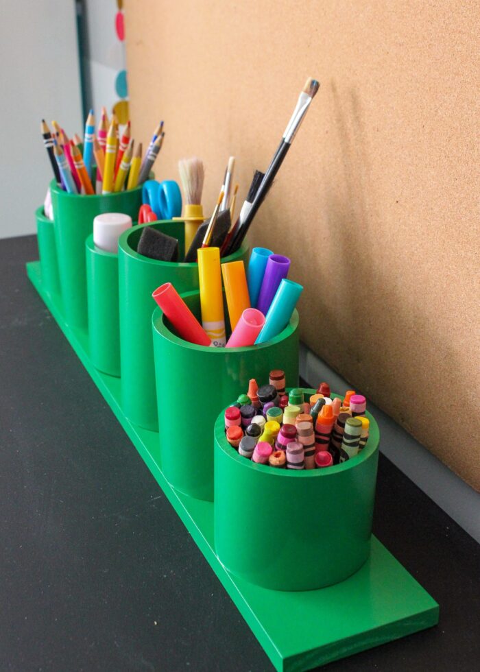 A green art caddy full of coloring supplies
