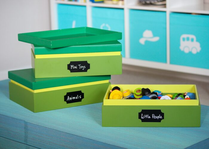 Small green wooden boxes holding small toys in a playroom