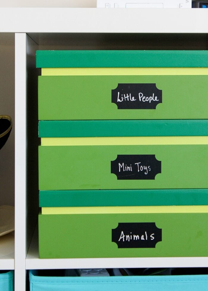 Wooden green boxes stacked on a white IKEA Kallax shelf