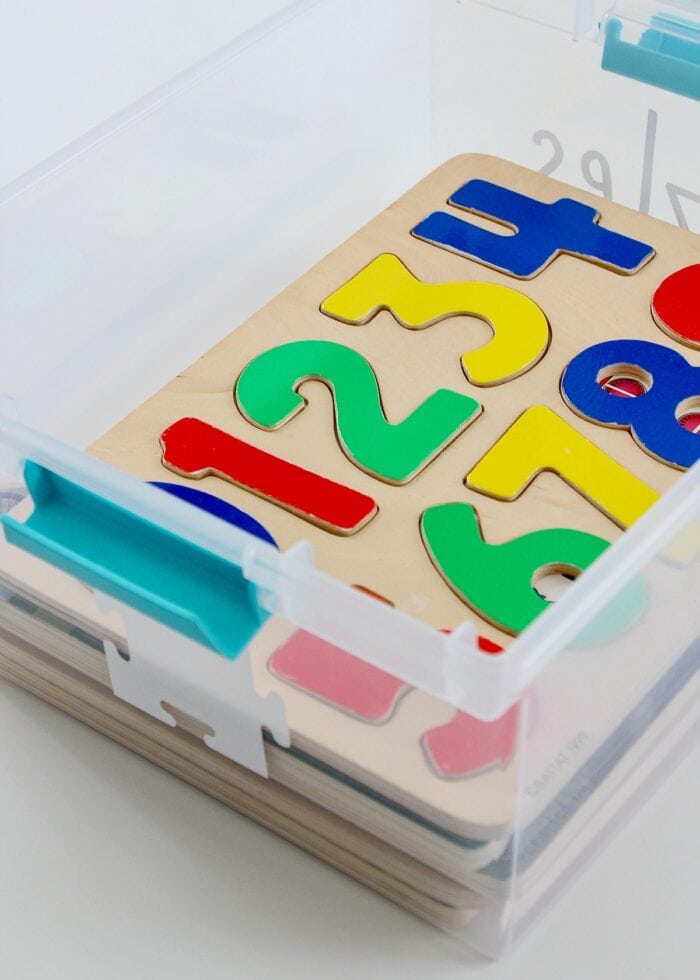 Toy Storage Ideas: Wooden puzzles loaded into a clear plastic box
