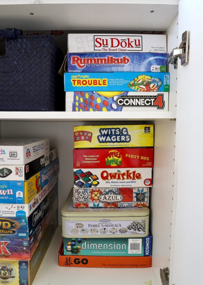Board games stored on white shelves