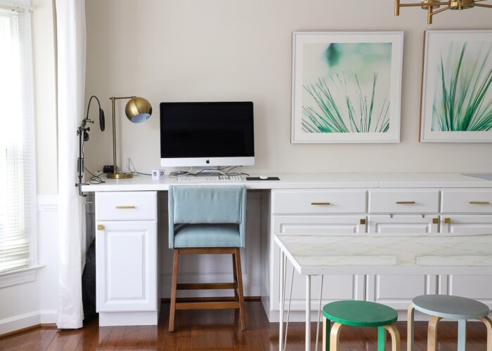 White cabinets and countertop setup as a desk with computer and blue chair