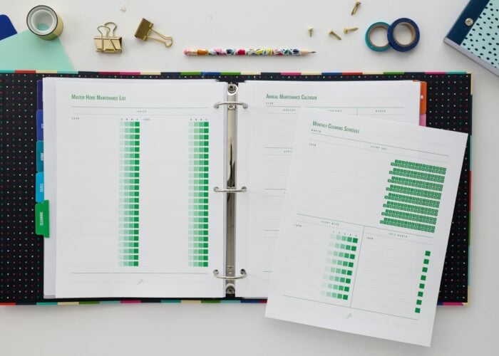 Binder open showing home cleaning schedule printables from The Family HUB
