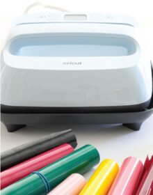 Cricut EasyPress 3 shown with rolls of iron-on vinyl