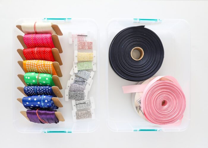 Bobbins and spools of organized ribbon in a clear tote