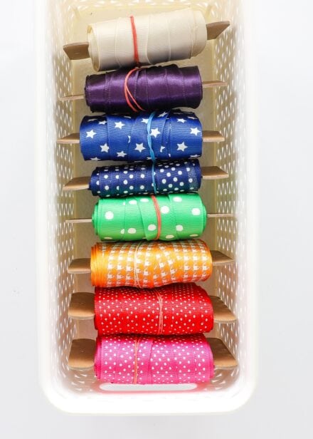 Bobbins of colorful ribbon in a white basket