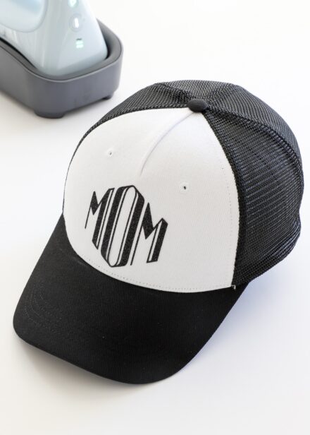 Mom monogram in black iron-on on Cricut Trucker Hat