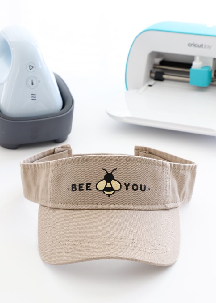 Bee You design on tan visor shown alongside Cricut Hat Press