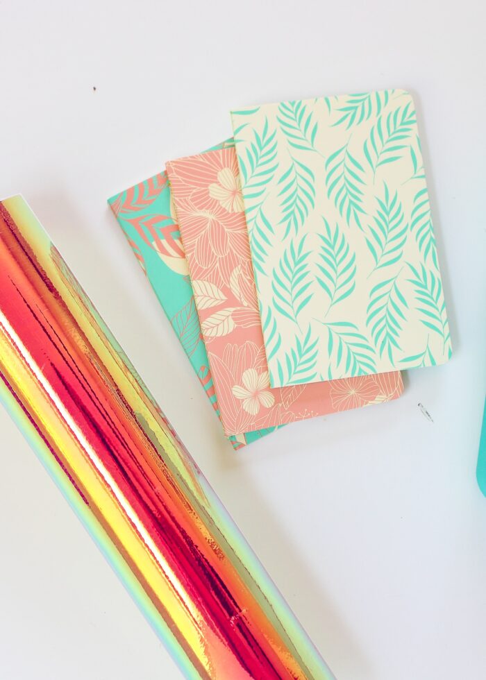 Roll of Cricut Holographic Vinyl alongside notebooks and pencil box
