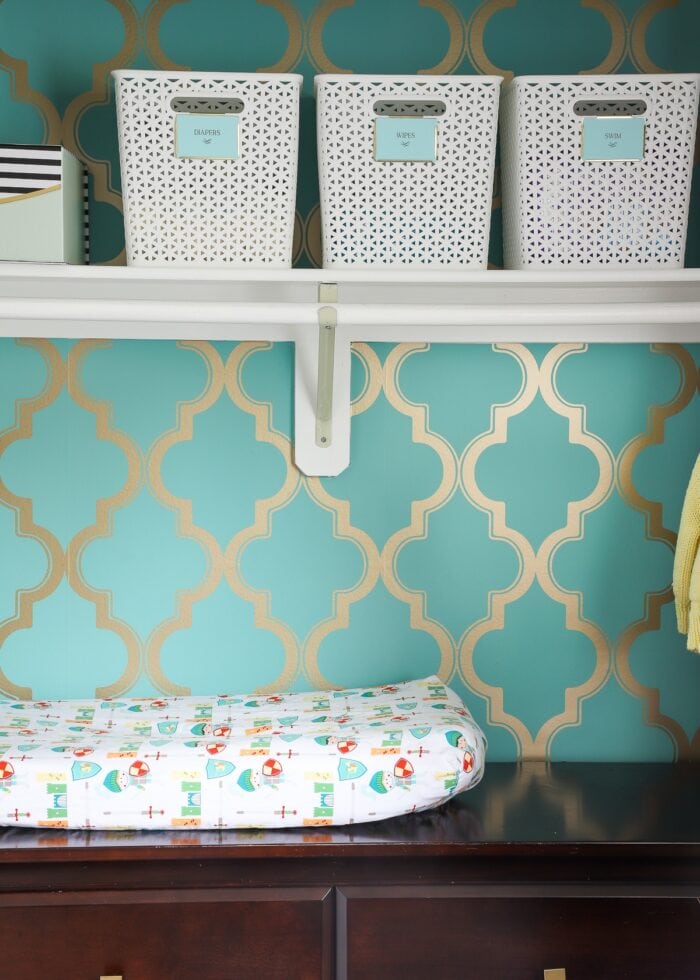 Nursery closet with dresser inside and wallpaper background