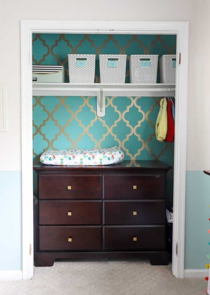 Nursery closet with dresser inside and wallpaper background