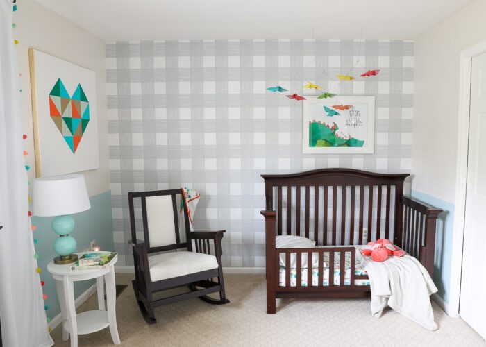 Nursery wall featuring grey checked wallpaper with dark nursery furniture