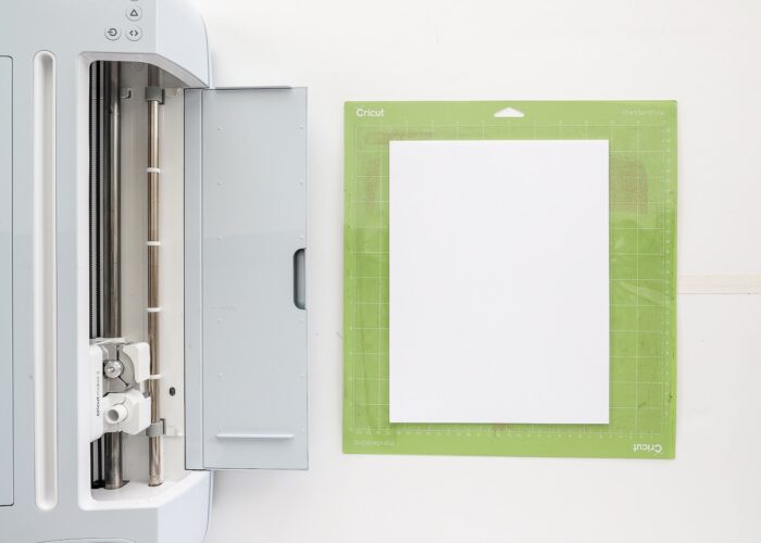 Top down shot of Cricut Maker 3 with green cut mat and white cardstock