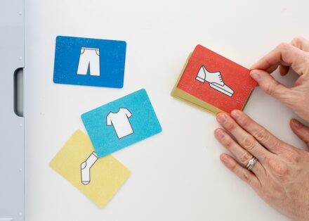 Hands sliding a clothing label into gold label holder