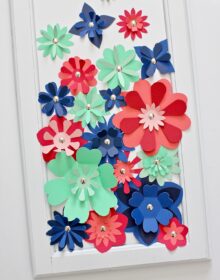 Red, blue, and green 3D flowers in a white frame