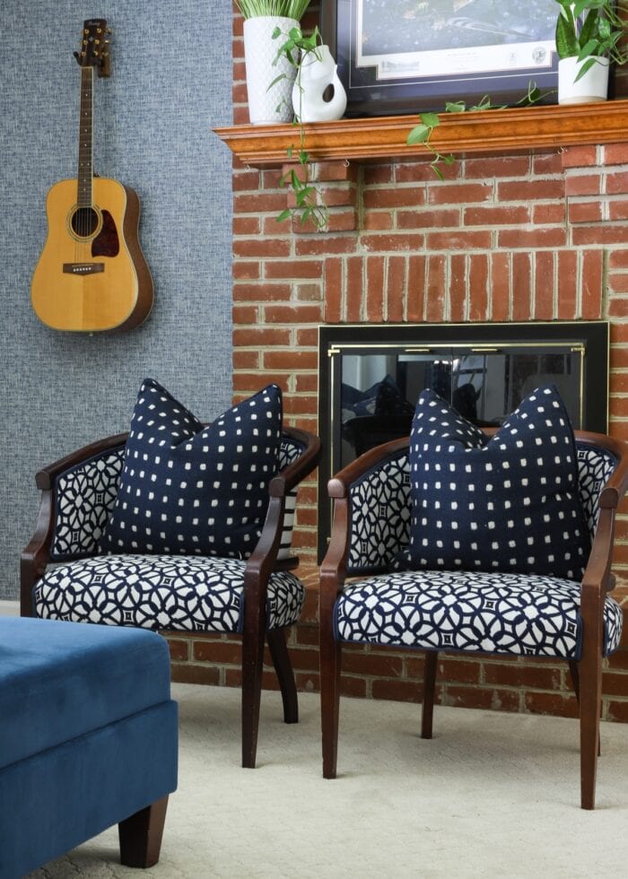 Blue and white patterned chairs sitting in front of a brick fireplace