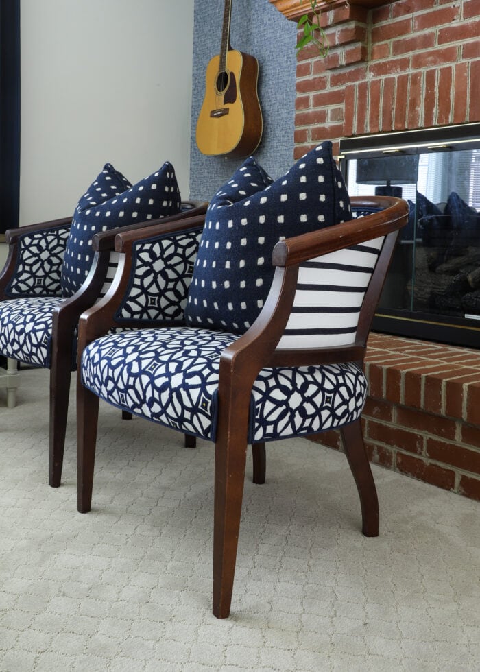 Blue and white patterned chairs sitting in front of a brick fireplace