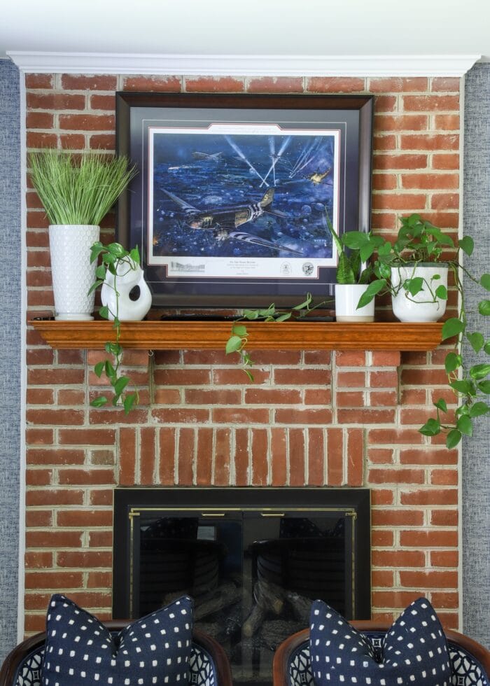 Brick fireplace with plants on the mantel in white pots