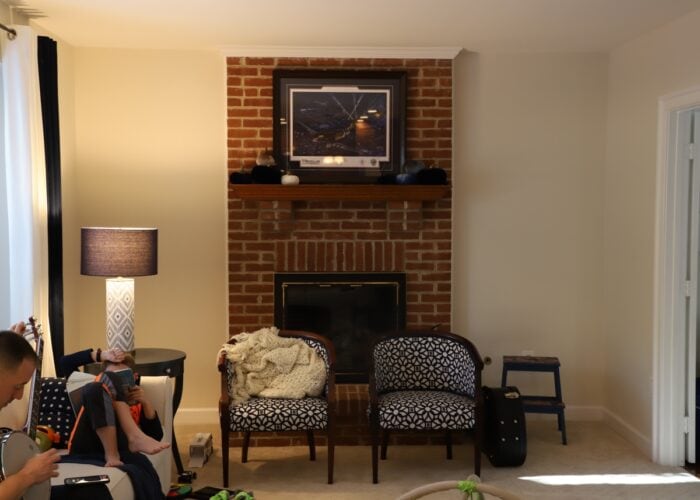 Dark family room with view of dated brick fireplace