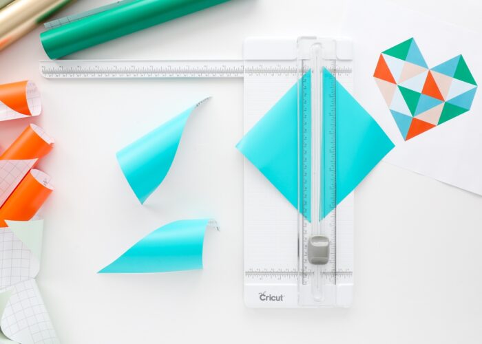 Cutting turquoise vinyl into triangles using a Cricut Paper Trimmer