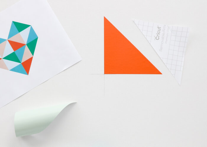 An orange vinyl triangle in the center of a white canvas