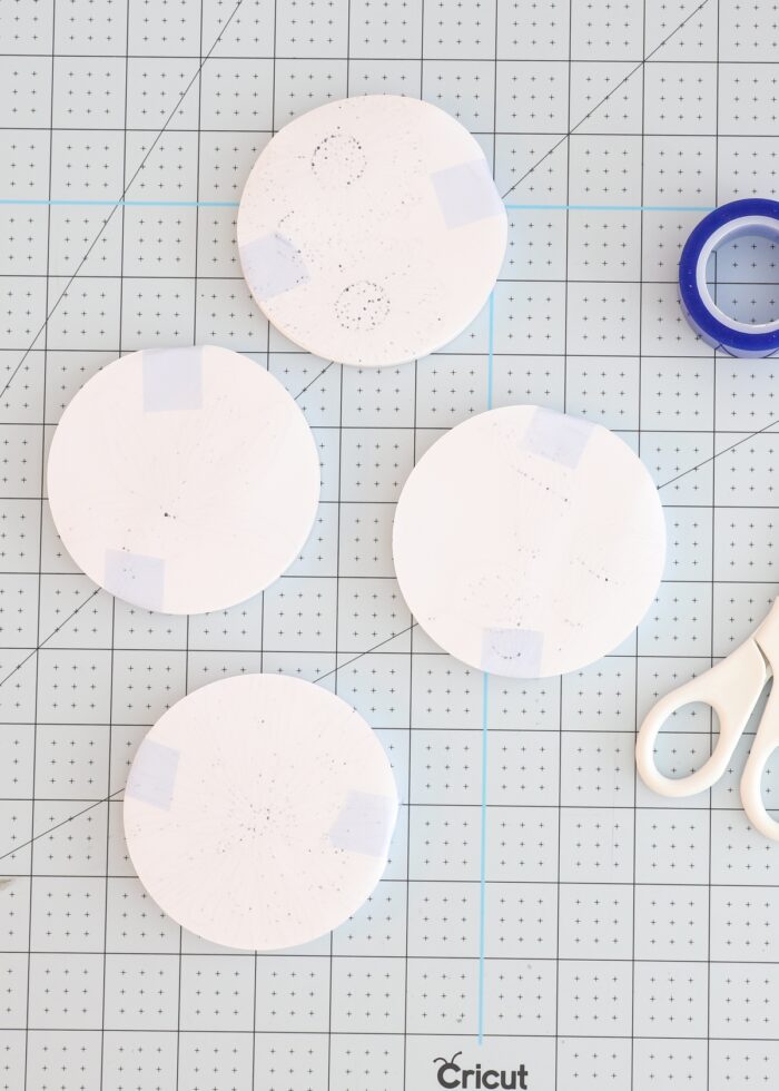 Cricut pen designs taped to white Cricut Infusible Ink Coasters