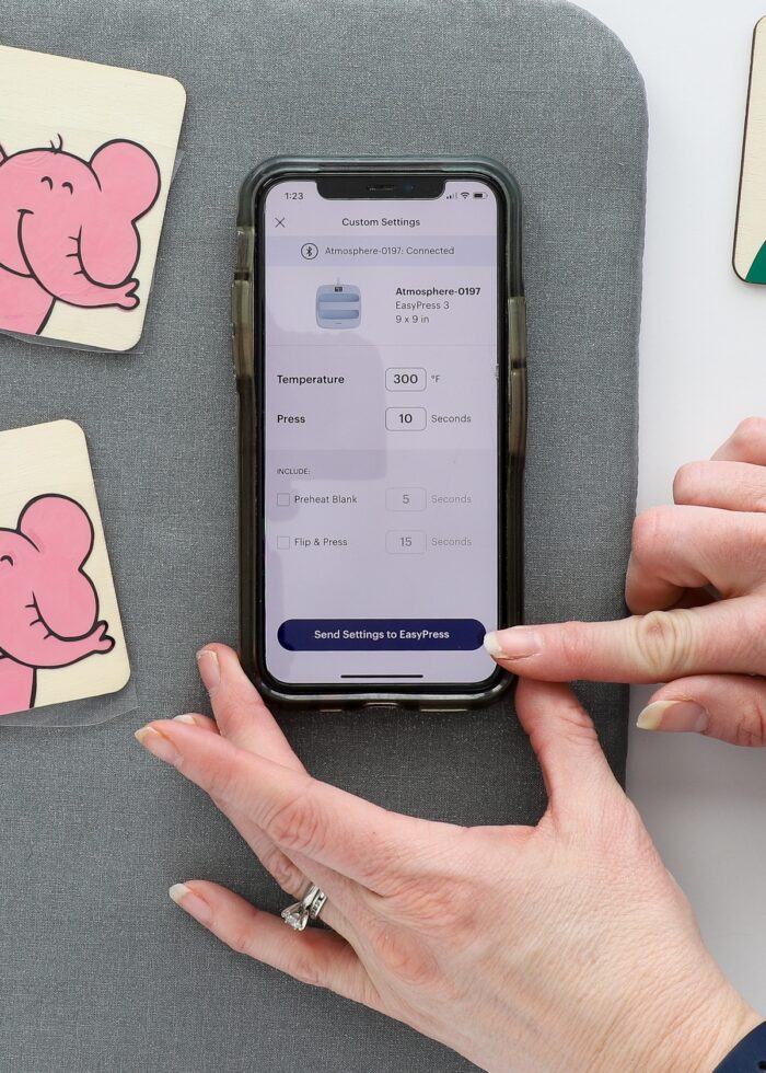 Hands pointing to Cricut Heat app on iPhone