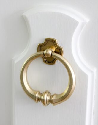 A newly cleaned brass knob on a white door
