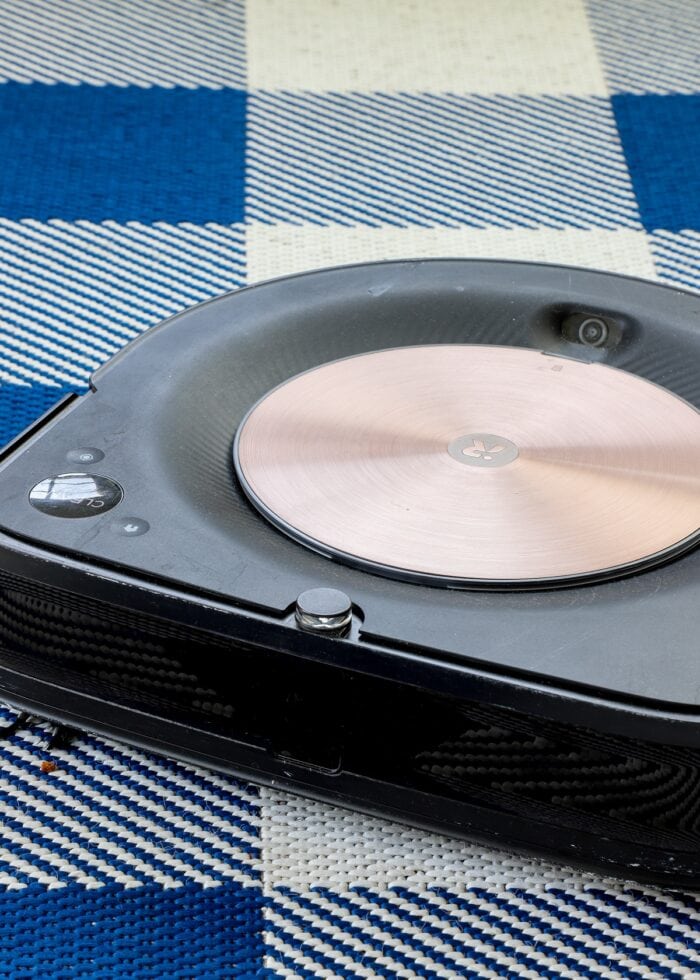 A robot vacuum on a blue-and-white rug